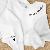Weißer Sweater mit Mama Schriftzug und Kindernamen auf dem Ärmel - Personalisiertes Geschenk von Love & Faith