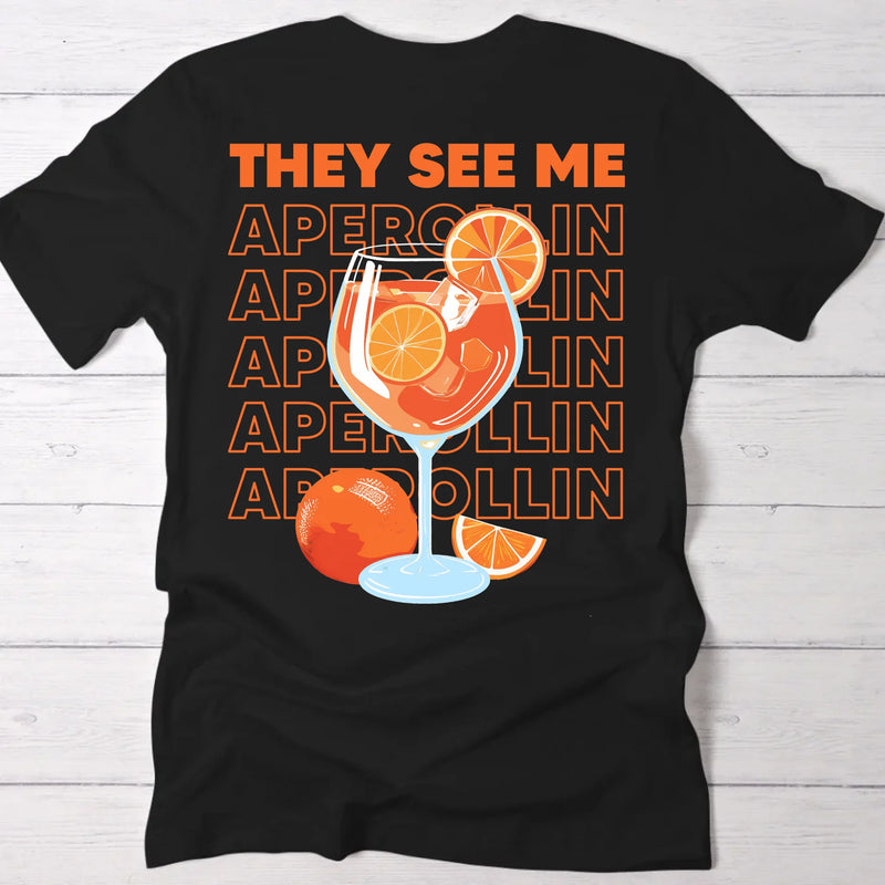 schwarzes Frauen T-Shirt Rückenprint mit "They see me aperolin" personalisiertesm Spruch als Sommer Geschenkidee von Love & Faith